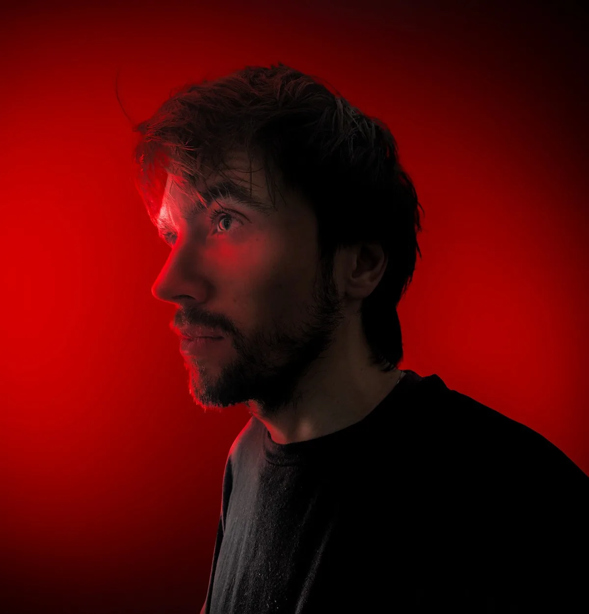 Retrato de Manuel García, diseñador freelance detrás de KVOUZ, con iluminación roja